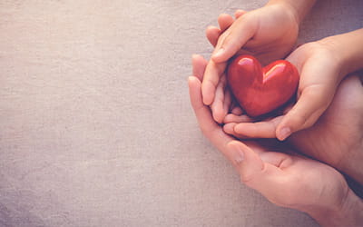 Hænder der holder et rødt hjerte, Q-Park tager socialt ansvar - csr