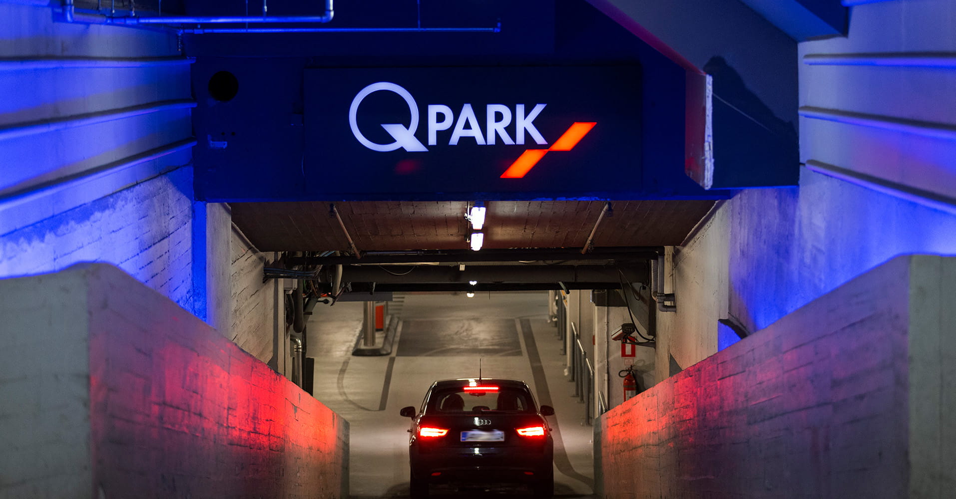 Q_Park Illum indkørsel med blå lys og en bil der bremser på vej ned