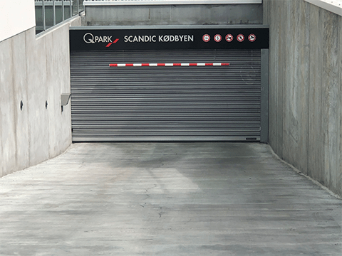 Entry to Q-Park Scandic Kødbyen parking facility- grey with a black sign above