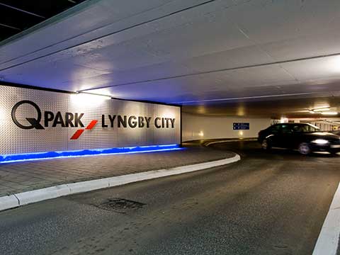 Indkørsel og rundkørsel til Q-Park Lyngby City. Sort bil kører ind