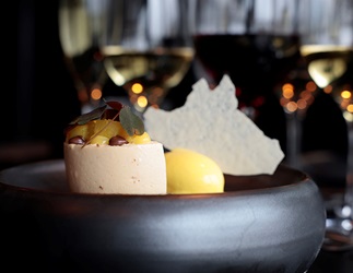 Lækker dessert anrettet på tallerken med to glas rødvin i baggrunden - Parkering Det Glade Vanvid