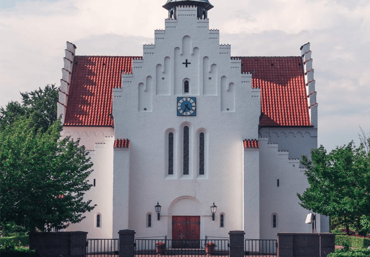 Aabyhøj church . A white building with a red roof 