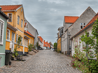 Bybillede Ebeltoft, brosten og gamle huse på en gråvejrsdag
