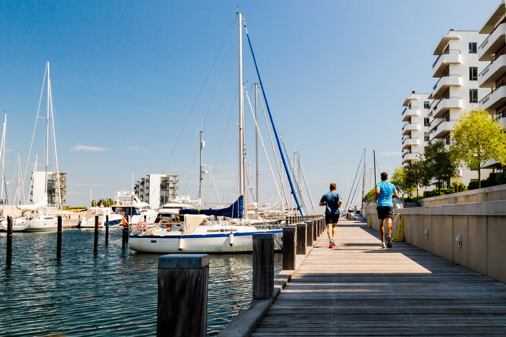 Hellerup havn ved Waterfront. To mennesker løber forbi lystbådshavn