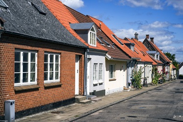 En lille gade i Middelfart med gamle huse tætbygget og solen skinner