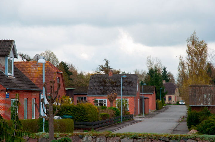 Nørre Alslev city with houses and flagpoles on a grey day
