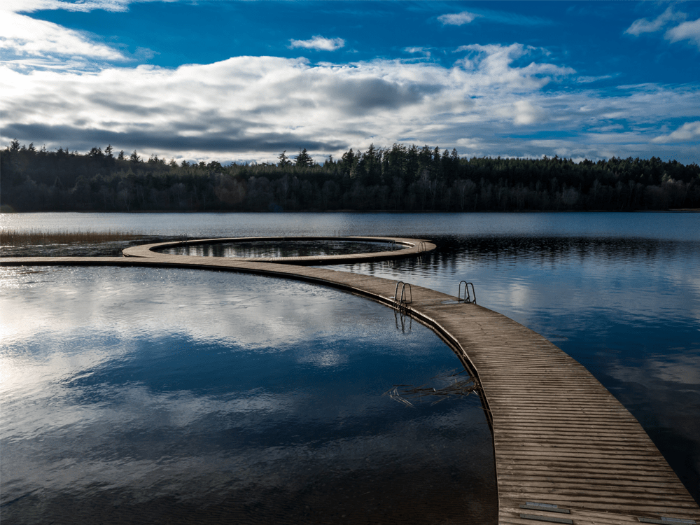 Almindsø Silkeborg. Spejlblank vand og en gangbro ud på vandet.
