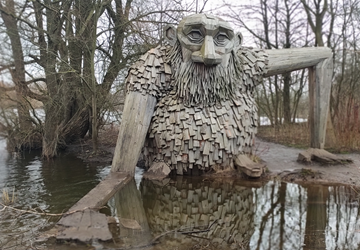 Wooden troll Friendly Teddy in a nature area around Taastrup