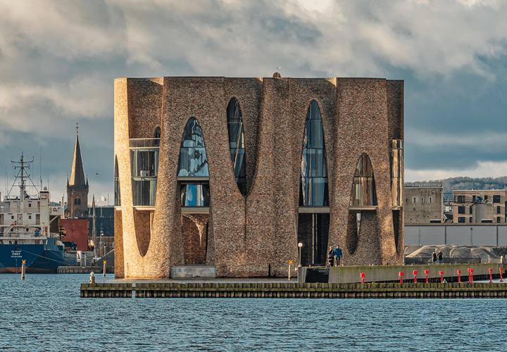 Fjordenhus house in Vejle. A building of cylinders in red brick and architectural glass panes.