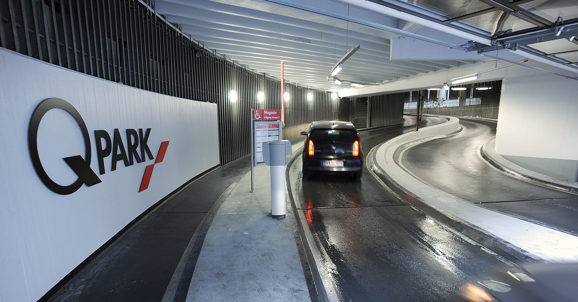 Q-Park Magasin entry with a barrier opening and a black car driving in