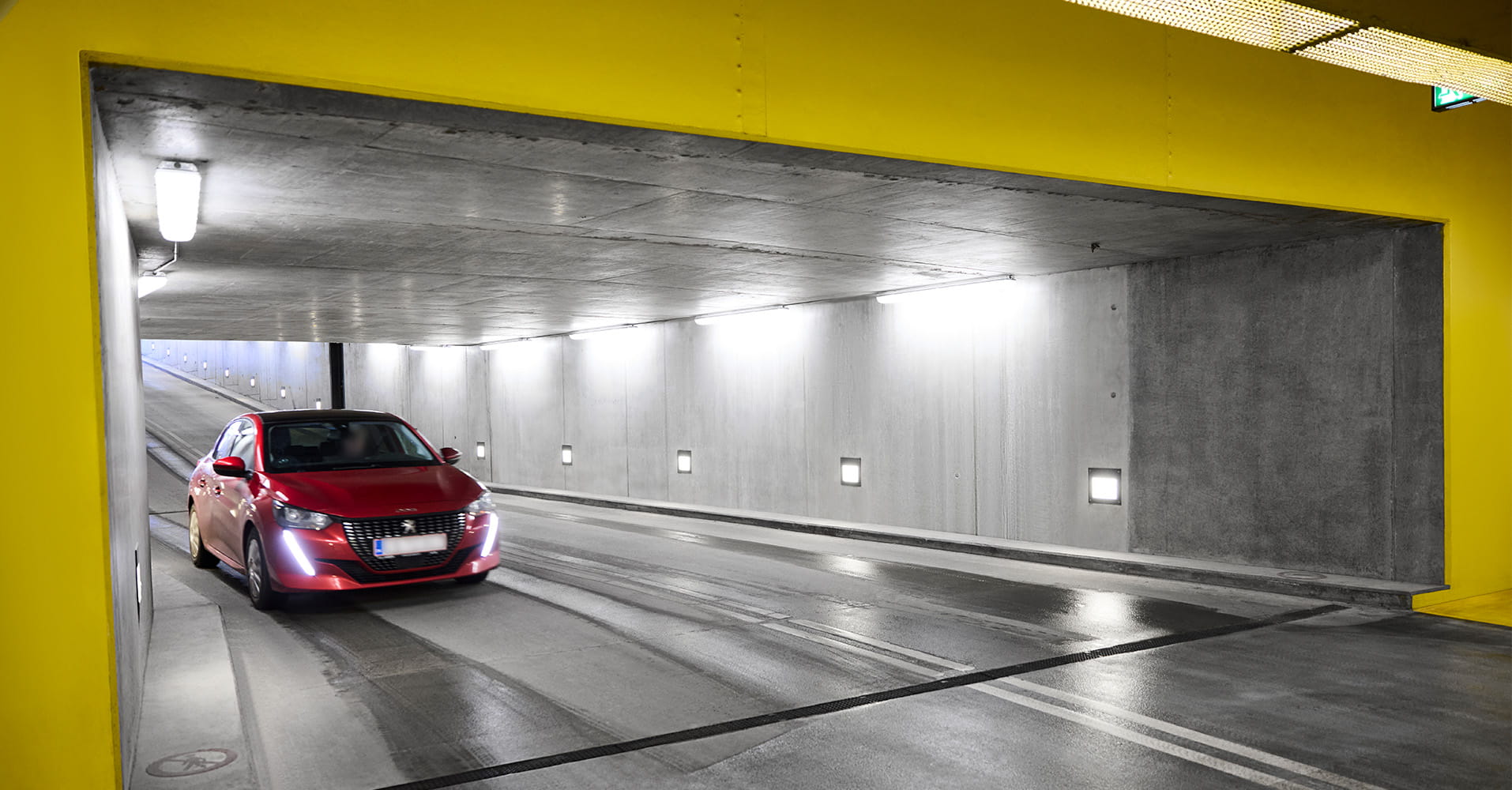 Q-Park Odense City indkørsel med en rød bil der kører gennem et gult område